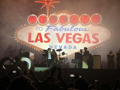 the band las vegas is performing in front of a welcome to fabulous las vegas sign