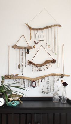 there is a wooden shelf with jewelry hanging on it