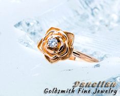 a gold ring with a diamond in the middle on top of snow - covered ground