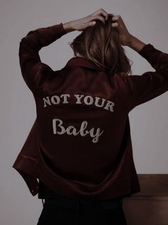 a woman wearing a jacket that says, not your baby on it's back