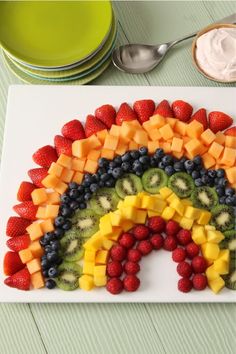 a rainbow shaped fruit platter on a table