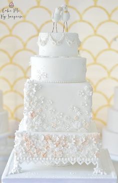 a white wedding cake with two birds on top