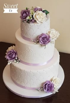 three tiered wedding cake with purple and white flowers