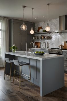 a large kitchen with an island in the middle and two stools at the end