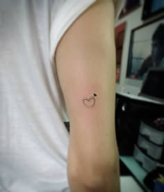 a small heart tattoo on the arm