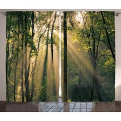 the sun shines through the trees in the forest curtains set on a window sill