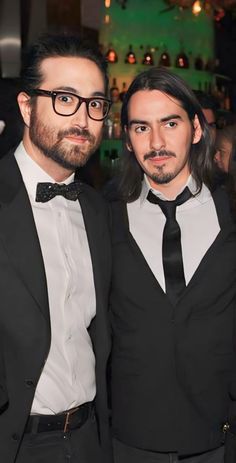 two men in tuxedos posing for the camera