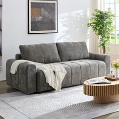 a living room filled with furniture and a coffee table in front of a painting on the wall