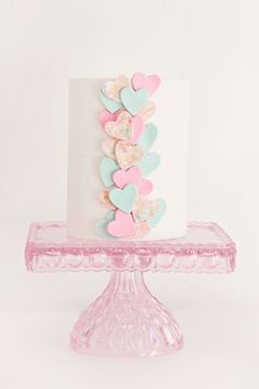 a white cake with pink and blue hearts on it