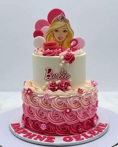 a birthday cake decorated with barbie dolls and decorations