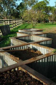 there are many metal boxes that have been dug into the ground for planters to grow