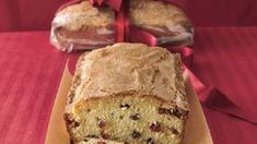 there is a loaf of bread on the table with two slices cut out and wrapped in red ribbon