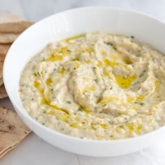 a white bowl filled with dip next to tortilla chips