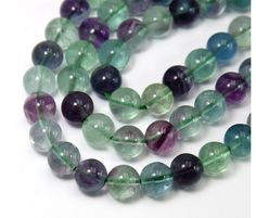 multicolored glass beads with green, purple and blue accents on a white background