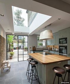 an open kitchen with skylights and stools