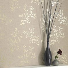 a vase with some flowers in it sitting on a shelf next to a wall paper