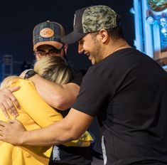 two men hugging each other outside at night