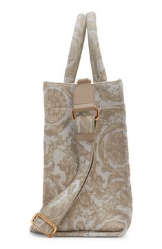 The label's signature Barocco pattern and an embroidered logo decorate this structured tote in a perfect everyday size. A removable, matching shoulder strap adds a hands-free carrying option to the classic style. Open top Top carry handles; removable, adjustable shoulder strap Exterior slip pocket Interior zip pocket Structured silhouette with flat base and protective leather feet Unlined Textile with leather trim Made in Italy Designer Handbags Luxury Cream Shoulder Bag With Adjustable Handle, Designer Beige Shoulder Bag With Adjustable Handle, Luxury Cream Bags With Adjustable Handle, Luxury Cream Bag With Adjustable Handle, Luxury Beige Bags With Adjustable Handle, Versace Gold, Top Top, Small Tote, Open Top