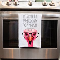 a towel hanging on an oven door saying, let's keep the dumblockery to a minnium today