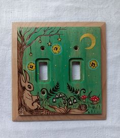 a green light switch cover with an image of a rabbit and tree in the background