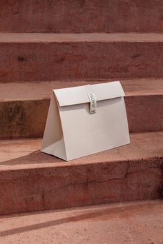 a white mailbox sitting on the steps in front of some stairs with no people