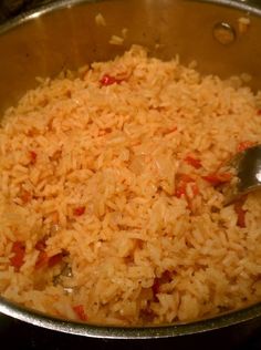 a large metal bowl filled with rice on top of a stove