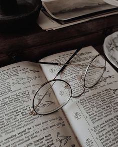 an open book with glasses sitting on top of it