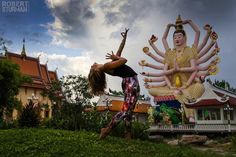 a woman standing in front of a giant statue with arms spread out and hands outstretched