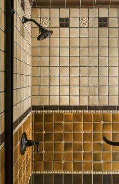 a tiled shower with two faucets in it