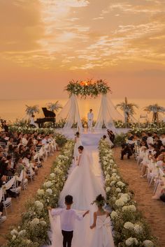 a bride and groom walking down the aisle at their wedding ceremony in front of an ocean view