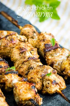 grilled chicken kabobs on skewers with mint garnish