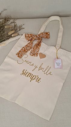 a white bag with gold lettering and a bow on the handle that says, you are my little simple