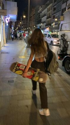 a woman is walking down the street with her skateboard