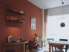 a dining room with orange walls and wooden furniture