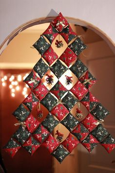 an origami christmas tree hanging in front of a mirror