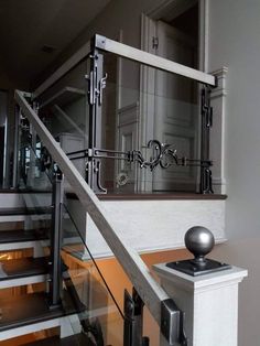 a staircase with glass railing and metal handrails