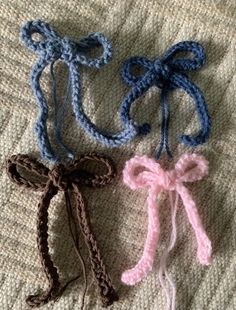 three crocheted bows are laying on a blanket