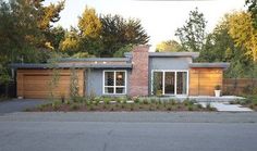 an image of a house that is in the middle of the street with trees around it