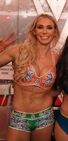 two women in bikinis standing next to each other and posing for the camera with their hands up