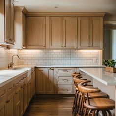 a kitchen filled with lots of counter top space and wooden chairs next to a sink