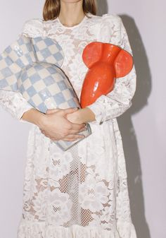 a woman in white dress holding an orange object