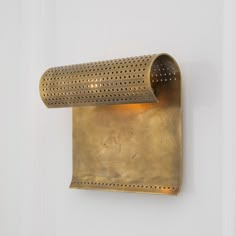 a wall light that is attached to the side of a white door with perfored metal