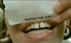 a woman holding up a piece of paper with the words watch the gap on it