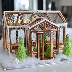 a ginger house with trees and snow around it