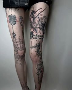 a woman's legs with tattoos on them and spider webs in the middle