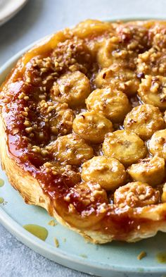 a pastry on a plate with sauce and nuts in the middle, ready to be eaten