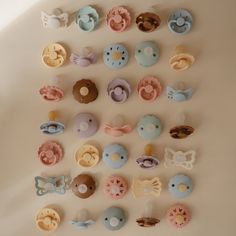 there are many different types of buttons on the wall, all in pastel colors