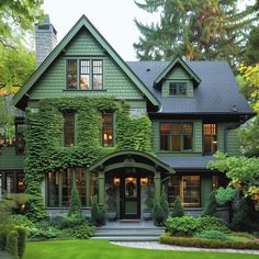 a large green house with ivy growing on it's walls and windows in the front yard