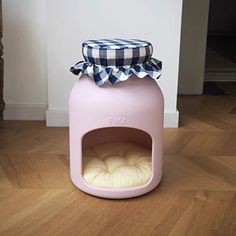 a pink dog house with a black and white checkered bow on top