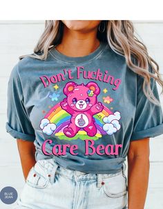 Indulge in rebellious comfort with our "I Don't Care Bear Vibes" T-shirt! This whimsical tee features a cheeky care bear boldly expressing your carefree attitude with a pair of unmistakable middle fingers and a vibrant rainbow backdrop. Crafted from soft, breathable fabric, this shirt guarantees both style and comfort. Embrace the carefree spirit and make a statement with this playful addition to your wardrobe. It's not just a shirt; it's an expression of your "don't give a care" attitude! *Unisex Sizing* Trendy Crew Neck T-shirt With Bear Print, Cute Bear Print Crew Neck T-shirt, Casual Bear Print T-shirt For Streetwear, Graphic Tee With Bear Print For Streetwear, Trendy Short Sleeve T-shirt With Bear Print, Rainbow Backdrop, Middle Fingers, Rainbow Tee, Care Bear